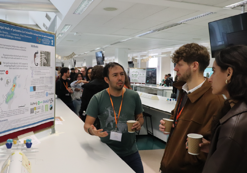 3 students having a discussion in front of an academic poster